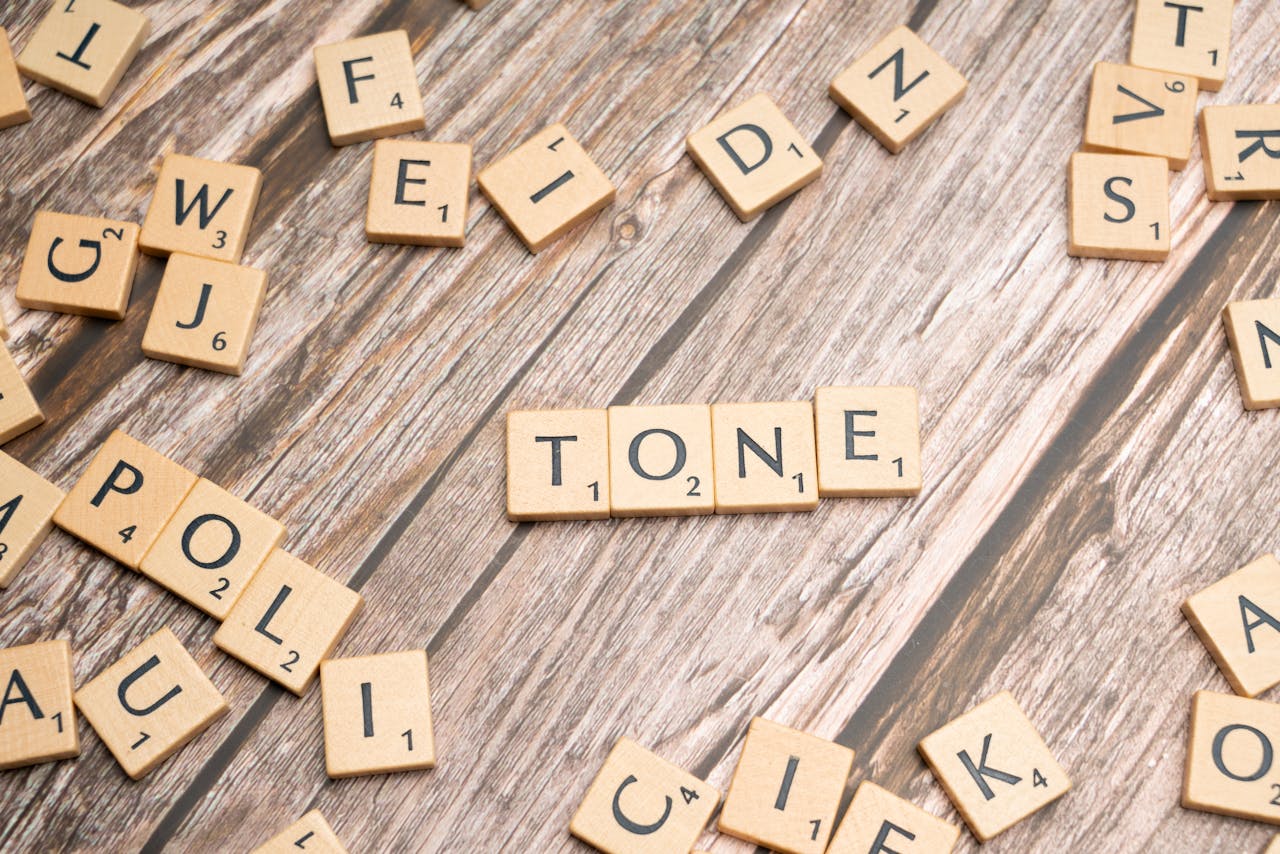 services-03 Wooden letter tiles arranged to spell "TONE" on a rustic wooden background. Ideal for typography themes.